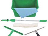 un gros plan sur un seau vert contenant une serpillière, une brosse et un chiffon de nettoyage
