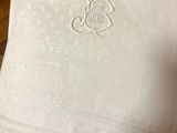 a white blanket with a monogram on it sitting on a table