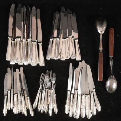 a lot of silverware on a table with spoons and knives