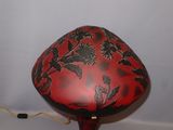 a red and black lamp that is on top of a table