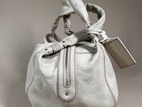 an image of a white purse with a tag on it