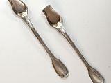 pair of silver plated utensils on a white surface