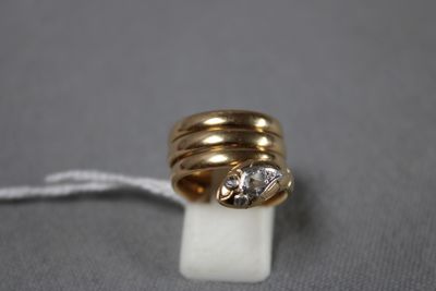 gros plan d'une bague en or surmontée d'un diamant