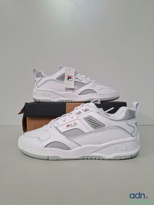 une paire de baskets blanches posée sur une boîte