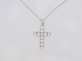 un pendentif en forme de croix en or blanc serti de diamants, monté sur une chaîne