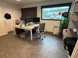 un bureau avec deux ordinateurs et une chaise dans une pièce