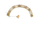 a close up of a gold bracelet with a chain attached to it