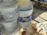 many buckets of paint sitting on a shelf in a room