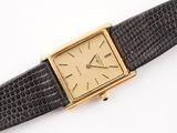 an image of a gold plated wrist watch with a black leather strap