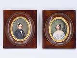 deux portraits encadrés représentant un homme et une femme, accrochés au mur
