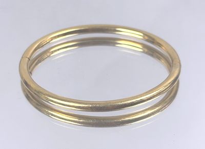 a close up of two gold rings on a white surface