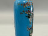 a blue vase with a painting of flowers on it