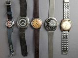 several different types of watches are lined up on a table