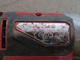a close up of a red and black corded drill