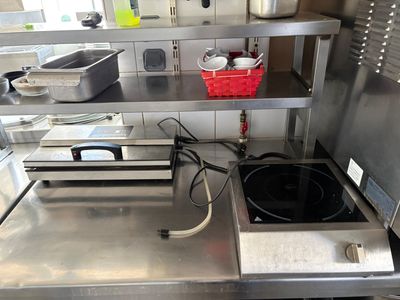 plan de travail en acier inoxydable dans une cuisine commerciale avec des casseroles et des poêles dessus