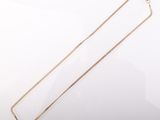a gold necklace with a chain on a white background