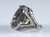 an image of a diamond and sapphire ring on a white surface
