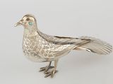 an antique silver bird with turquoise eyes on a white background
