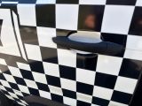 a black and white checkered car parked on the side of the road