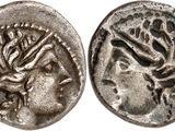 a silver coin with a head of a woman and a snake