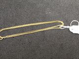 a close up of a gold chain with a tag on it