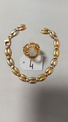 un gros plan d'un bracelet en or sur lequel est enfilée une bague