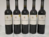 six bottles of wine are lined up on a table