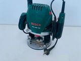 a close up of a green electric router on a white surface