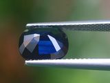 un gros plan d'un diamant bleu tenu par une pince