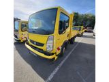 Le camion jaune est garé sur le parking, à côté d'autres camions.