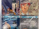 quatre bandes dessinées posées sur une surface blanche avec un fond bleu