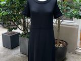 a black dress on a mannequin stand in front of a store