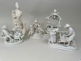 Plusieurs figurines représentant des personnages asiatiques sont exposées sur une surface blanche.