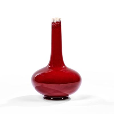 a red vase that is sitting on a white surface