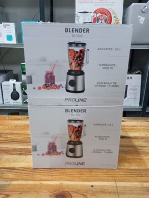 two boxes of blenders sitting on top of a wooden table