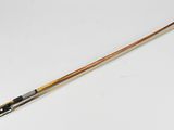 a wooden stick with a long handle on a white surface