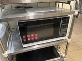 a microwave that is sitting on a shelf in a kitchen