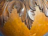 a brown vase with a gold decoration on it