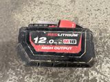 a close up of a red lithium battery on a concrete surface