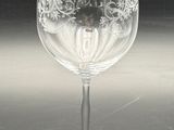 a clear wine glass with a red label on it