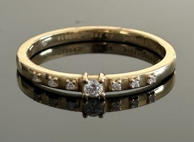 gros plan d'une bague en diamant sur une surface réfléchissante