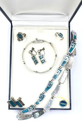 bijoux argentés et bleus disposés dans un coffret sur un fond blanc