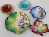 four different colored dishes sitting on a white surface