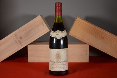 a bottle of wine sitting on a table next to a wooden box