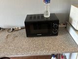 a microwave and a bottle of water on the counter