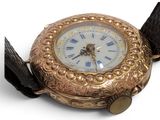 a gold watch with roman numerals on the face