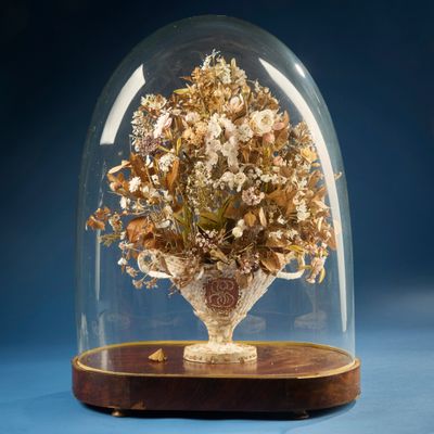 un dôme en verre renfermant un vase de fleurs
