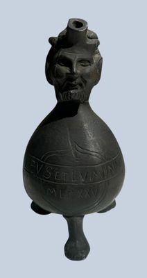 a black vase with a man ' s face on it