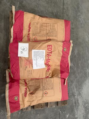deux sacs de ciment sont posés sur une palette dans un entrepôt