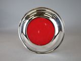 silver plate with a red glass in the middle of it